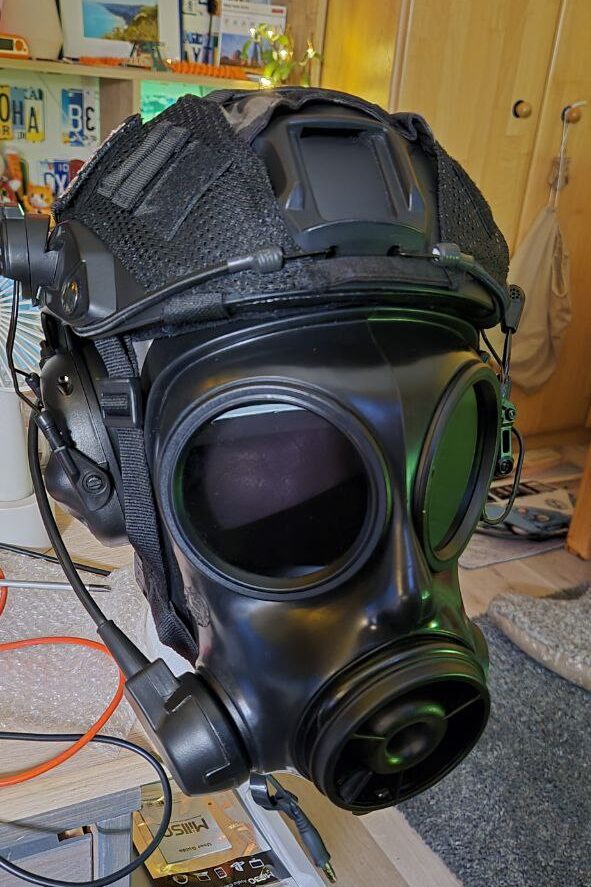 A styrofoam head wearing an S10 mask with tinted lenses. The clansman microphone is attached to the mask and a black tactical helmet.